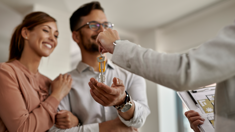 Couple receiving keys from their real estate agent